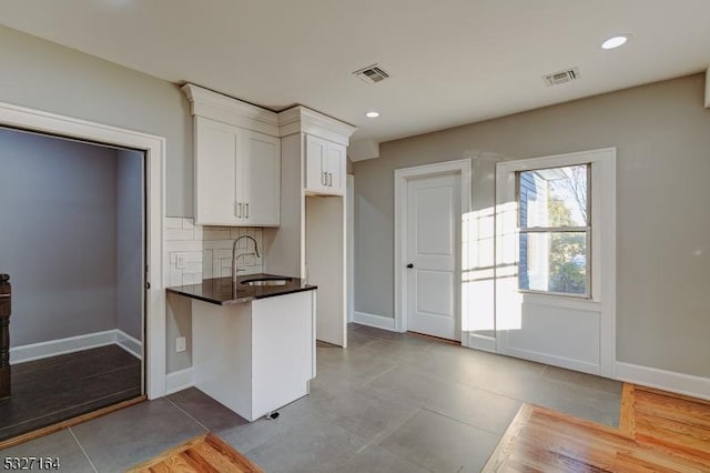 kitchen with sink, white cabinets, and decorative backsplash