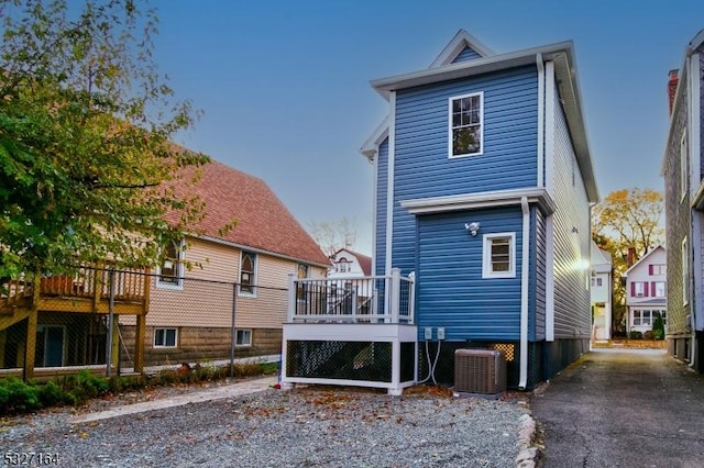 back of house with a wooden deck and central AC