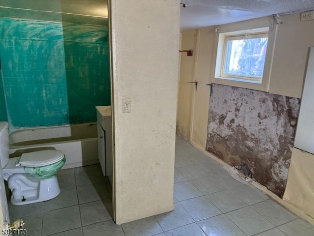 bathroom featuring a textured ceiling, toilet, and tile patterned floors