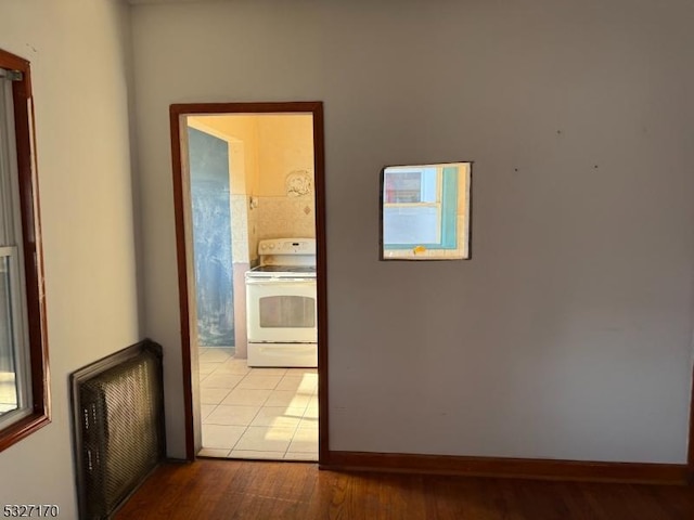 corridor featuring wood finished floors, visible vents, and baseboards