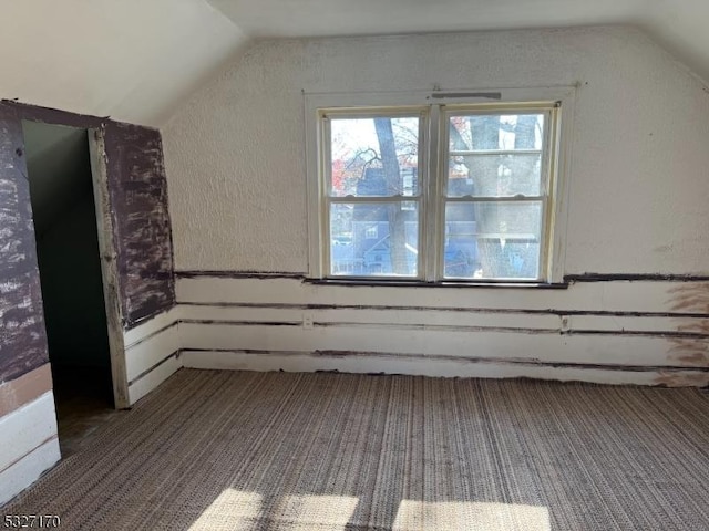 bonus room featuring lofted ceiling and carpet