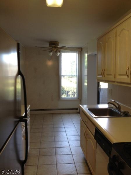 kitchen featuring dishwasher, sink, ceiling fan, light tile patterned floors, and stainless steel refrigerator