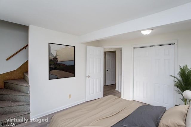 bedroom with wood-type flooring and a closet