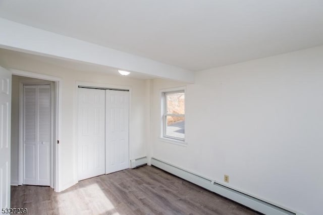 unfurnished bedroom with light hardwood / wood-style floors and baseboard heating