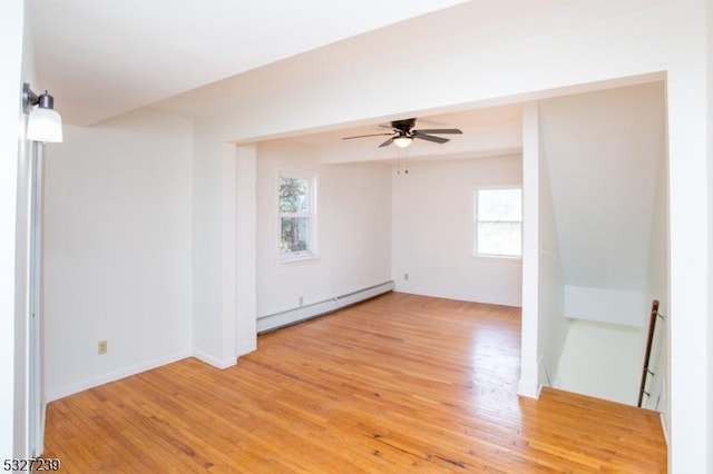 unfurnished room featuring hardwood / wood-style floors, a baseboard radiator, a wealth of natural light, and ceiling fan