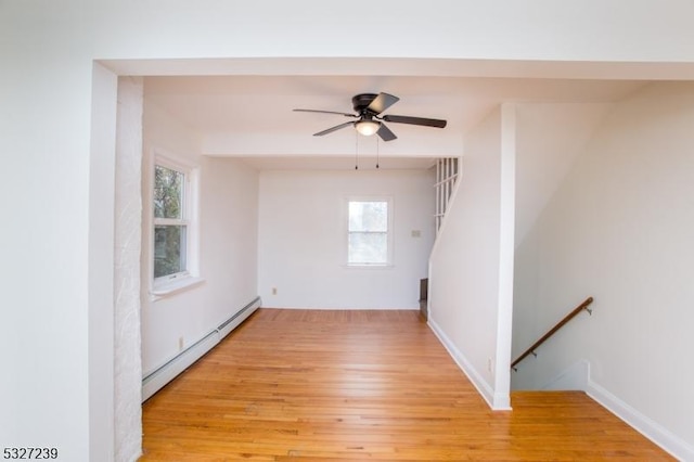 spare room with a baseboard radiator, ceiling fan, and light hardwood / wood-style floors