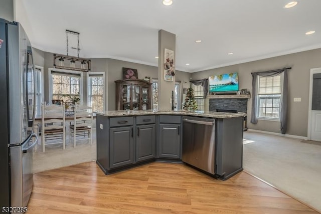 kitchen with light carpet, appliances with stainless steel finishes, gray cabinets, and a healthy amount of sunlight