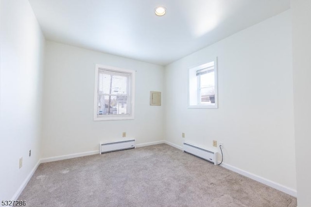 unfurnished room with a baseboard radiator and light colored carpet