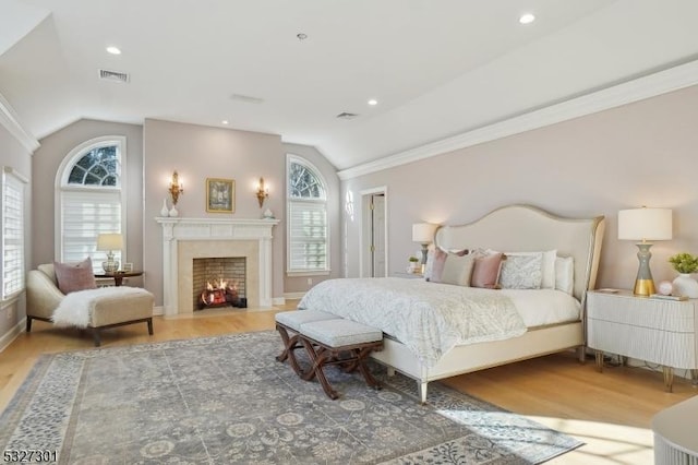 bedroom with hardwood / wood-style floors, ornamental molding, multiple windows, and vaulted ceiling