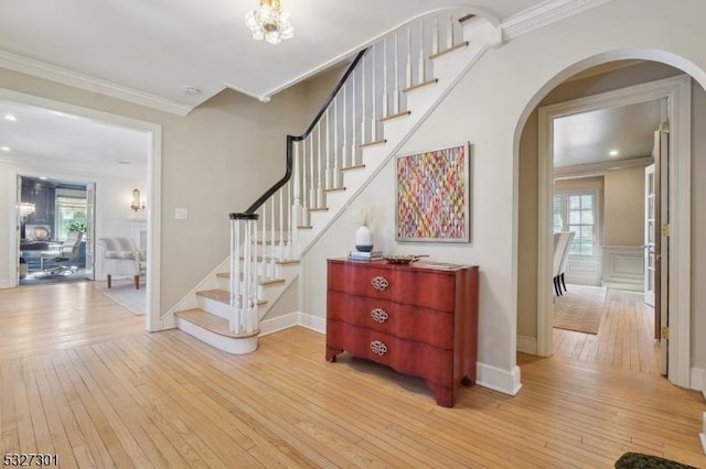 stairs with a wealth of natural light, hardwood / wood-style flooring, and ornamental molding