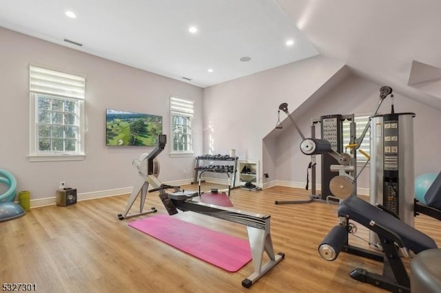 exercise area with vaulted ceiling, light hardwood / wood-style flooring, and plenty of natural light