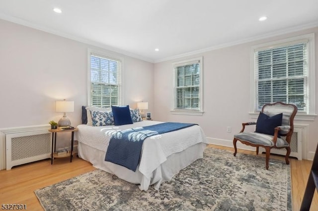 bedroom featuring radiator, ornamental molding, and light wood-type flooring