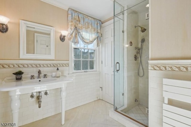 bathroom with tile patterned floors, tile walls, and a shower with shower door