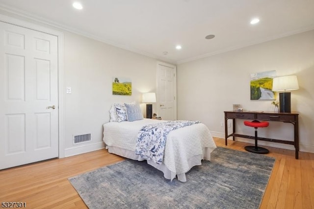 bedroom with hardwood / wood-style floors and crown molding