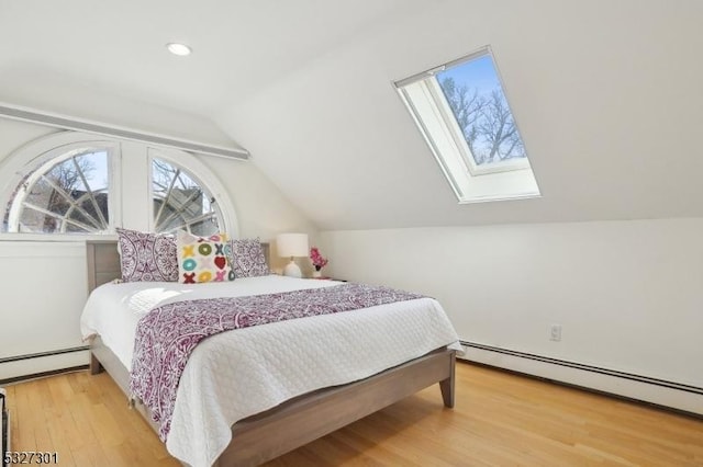 bedroom with hardwood / wood-style flooring, lofted ceiling with skylight, and baseboard heating