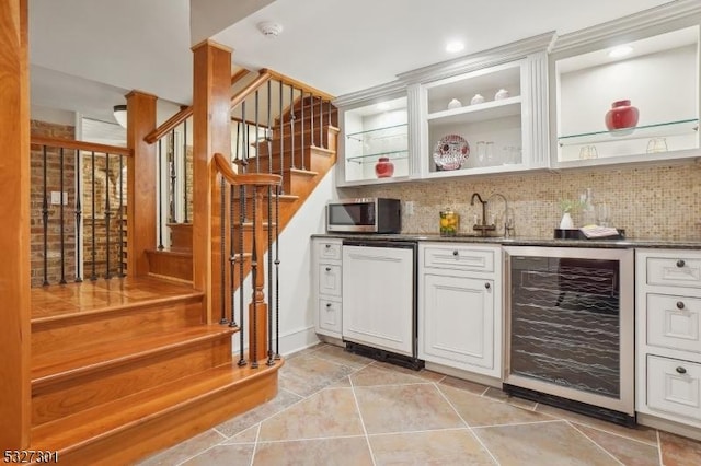 kitchen with dark stone counters, white cabinets, wine cooler, decorative backsplash, and dishwashing machine