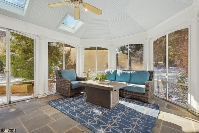 sunroom featuring vaulted ceiling with skylight, ceiling fan, and a healthy amount of sunlight