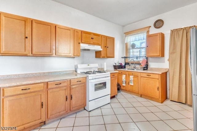 kitchen featuring light tile patterned flooring, gas range gas stove, and sink