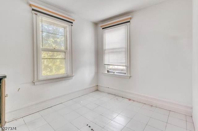 tiled spare room with a healthy amount of sunlight