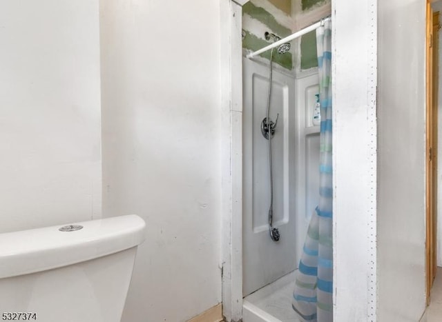 bathroom featuring a shower with shower curtain and toilet