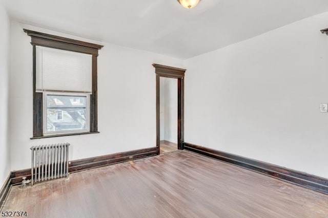 spare room with hardwood / wood-style flooring and radiator