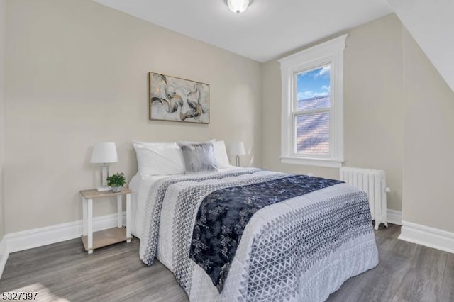 bedroom featuring radiator heating unit and dark hardwood / wood-style flooring