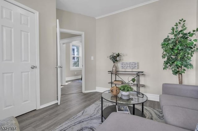 living area featuring hardwood / wood-style flooring and ornamental molding