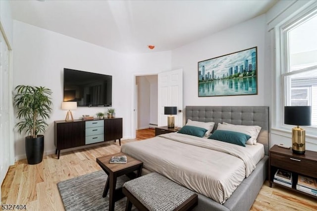 bedroom with light hardwood / wood-style flooring and multiple windows
