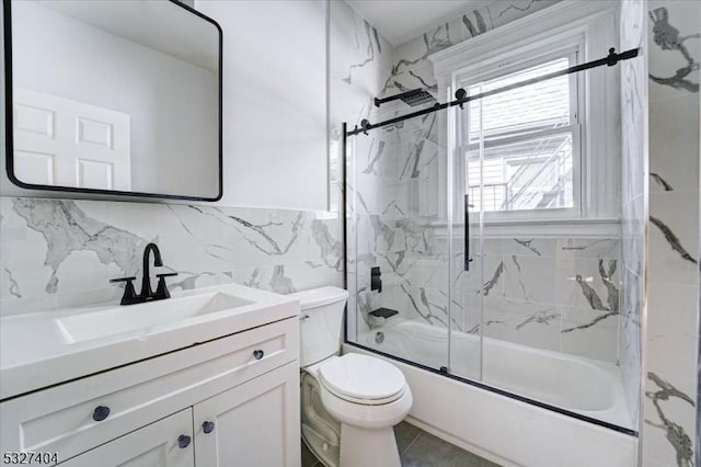 full bathroom featuring vanity, combined bath / shower with glass door, toilet, tile walls, and tasteful backsplash