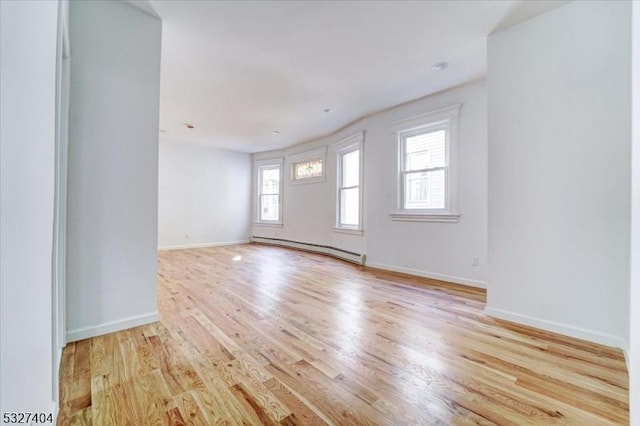 empty room featuring light hardwood / wood-style flooring and baseboard heating