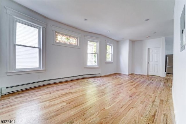 spare room featuring light wood-type flooring and a baseboard radiator