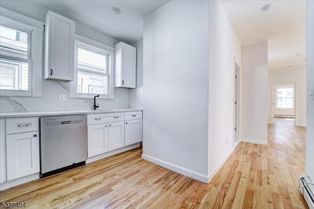kitchen featuring dishwasher, white cabinets, light hardwood / wood-style floors, and sink