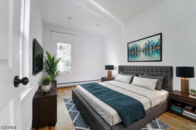 bedroom featuring light wood-type flooring and a baseboard radiator
