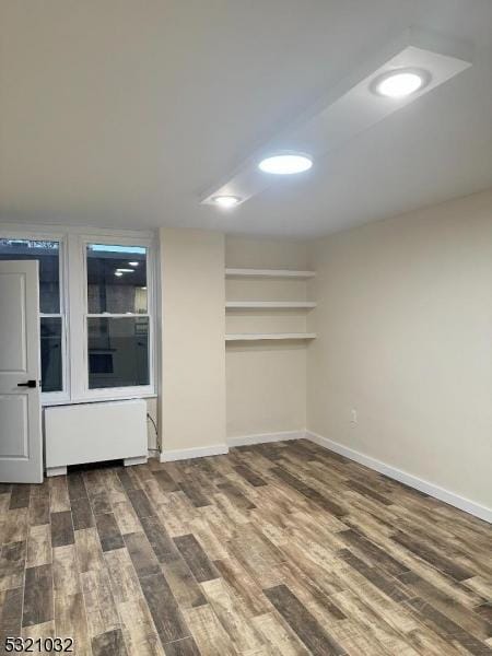 spare room with hardwood / wood-style floors and radiator heating unit