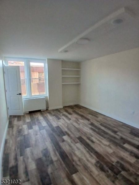 unfurnished bedroom featuring radiator and wood-type flooring