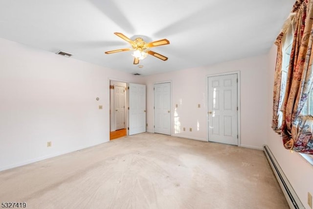 carpeted spare room with ceiling fan and a baseboard heating unit