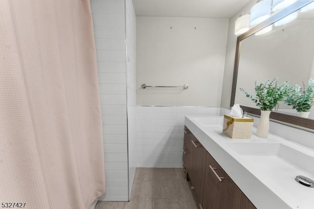 bathroom with vanity and tile walls