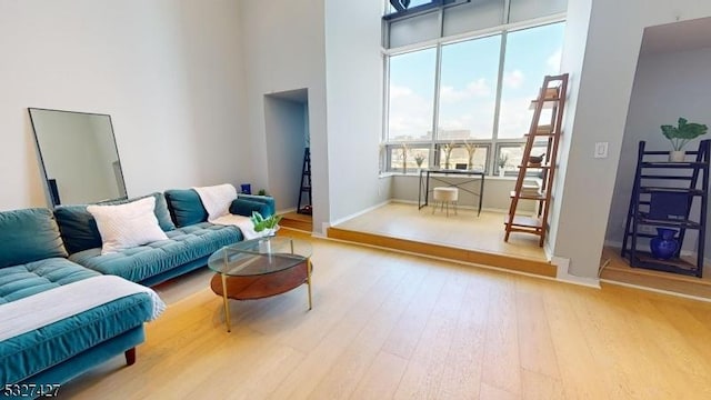 living room with hardwood / wood-style floors and a towering ceiling