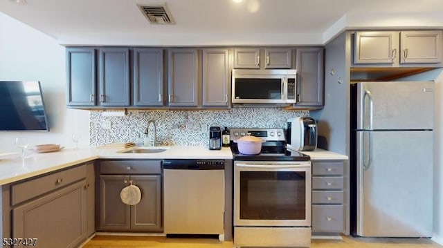 kitchen with decorative backsplash, sink, and stainless steel appliances