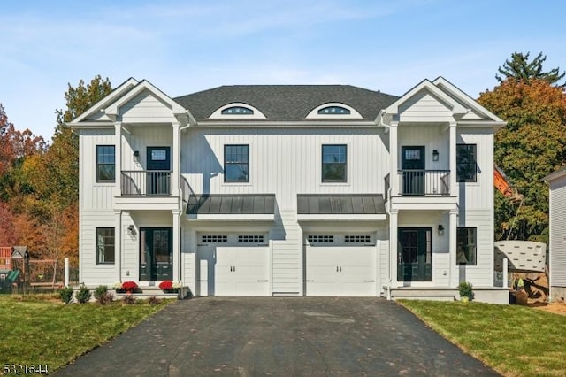 view of front of house with a garage, a balcony, and a front yard