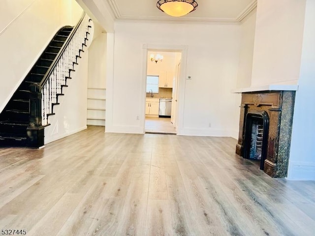 unfurnished living room featuring hardwood / wood-style floors, ornamental molding, and sink