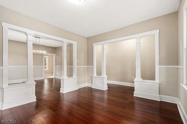 unfurnished room with dark hardwood / wood-style floors and an inviting chandelier