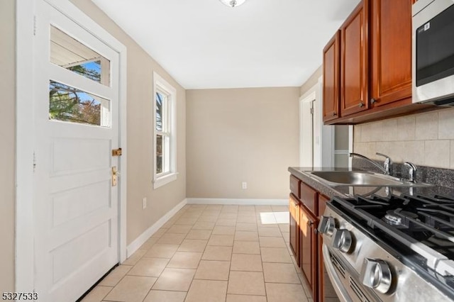 kitchen featuring light tile patterned floors, stainless steel appliances, tasteful backsplash, and sink