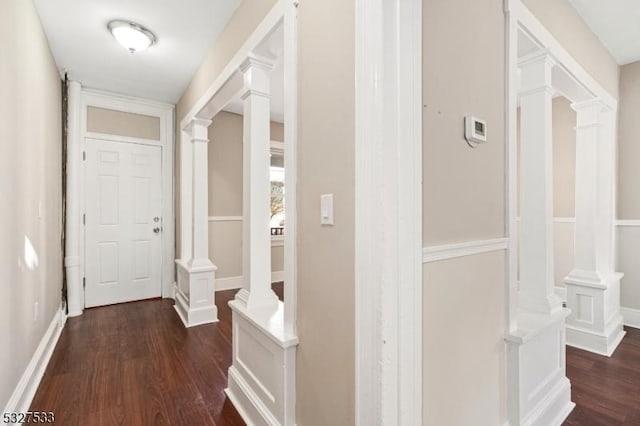 hall with dark hardwood / wood-style floors and decorative columns