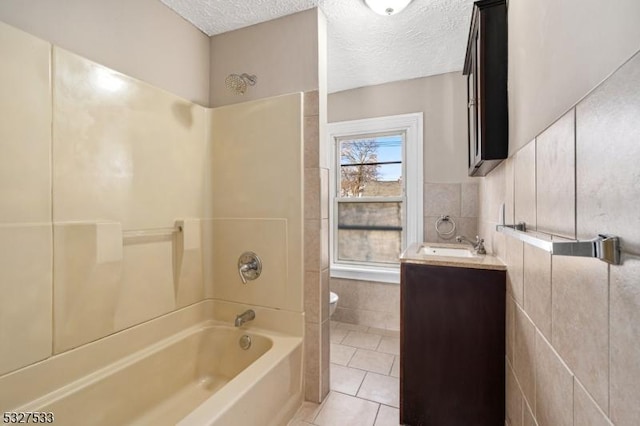 full bathroom featuring vanity, a textured ceiling, tile walls, and tile patterned flooring