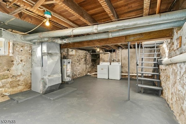 basement with washing machine and clothes dryer, heating unit, and water heater