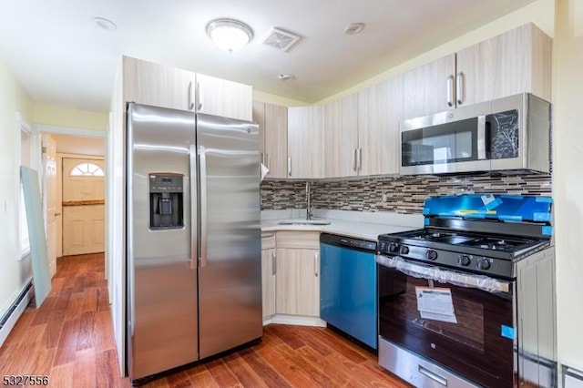 kitchen featuring tasteful backsplash, sink, dark wood-type flooring, and appliances with stainless steel finishes