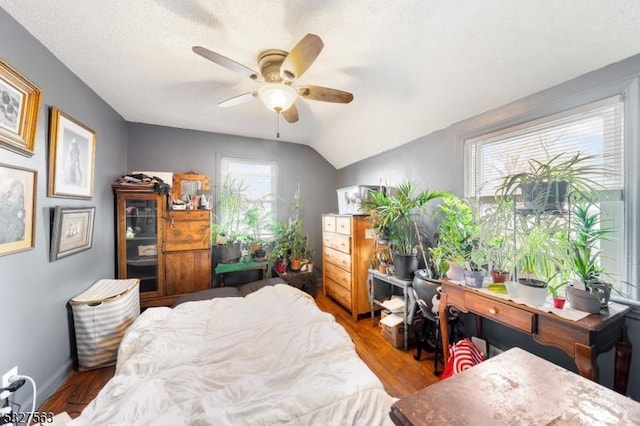 bedroom with hardwood / wood-style floors, ceiling fan, and vaulted ceiling