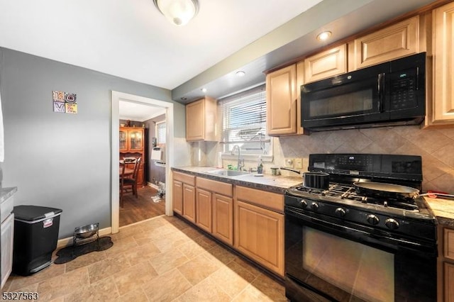 kitchen featuring black appliances, backsplash, light wood-type flooring, and sink