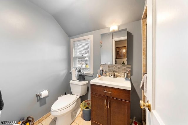 bathroom with toilet, vanity, tile patterned floors, and lofted ceiling